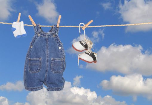 Baby Boy Clothes Hanging Outdoors Against a Bright Blue Sky