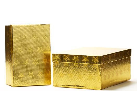 two closed golden present boxes with stars on white background