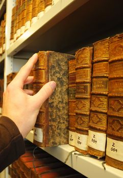 old books in a library with hand showing education concept