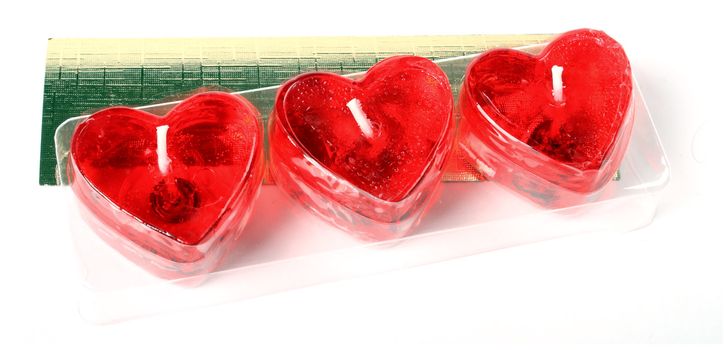row of red heart candles isolated over white