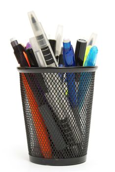 An assortment of pens, markers and more are isolated in a mesh holder.