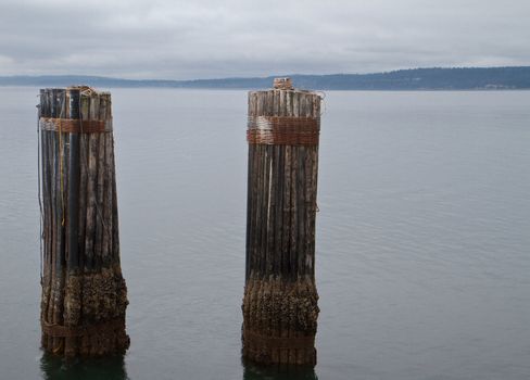 Two old weathered ol Mooring Piers under a overcast sky