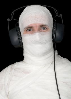 Man in bandage with ear-phones on black