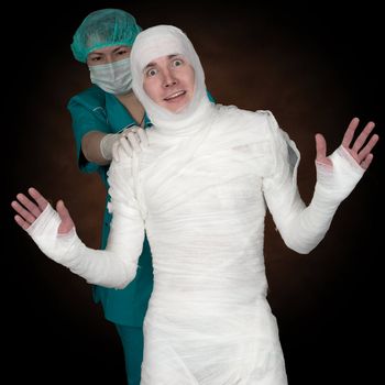 Man in bandage and nurse on black background