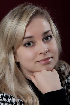 Portrait of the young smiling girl on a dark background