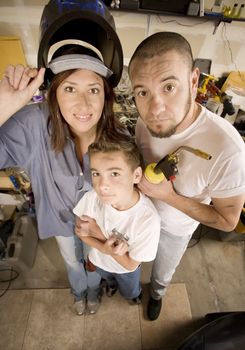 Funny Hispanic family in garage with variety of tools