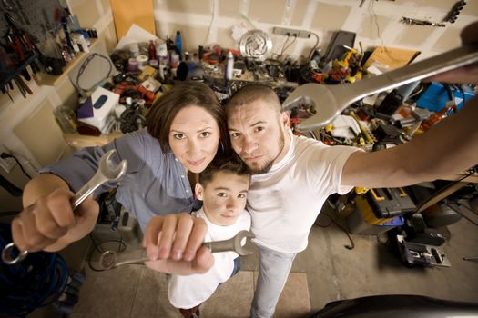 Funny Hispanic family in garage with crescent wrenches