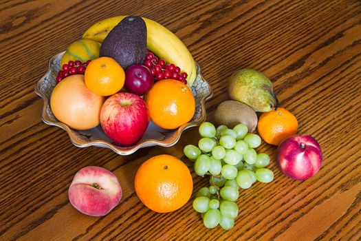 Selection of colorful, fresh, natural looking fruit in an old bowl on wooden background