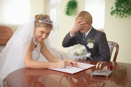 Marriage registration. The bride is happy. The groom in grief.