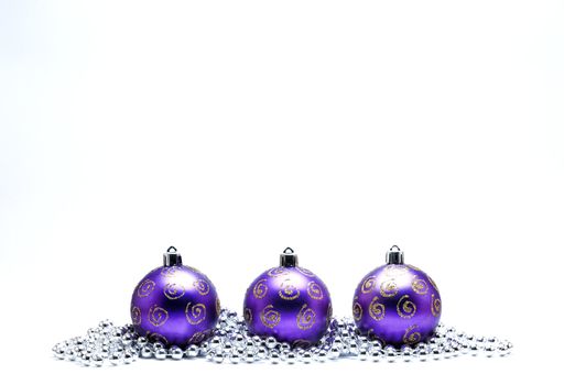 Purple Christmas Baubles with Gold Glitter and Silver Beads on a White Background.