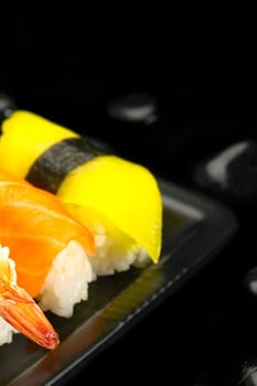 fresh assorted colorfull sushi plate over black