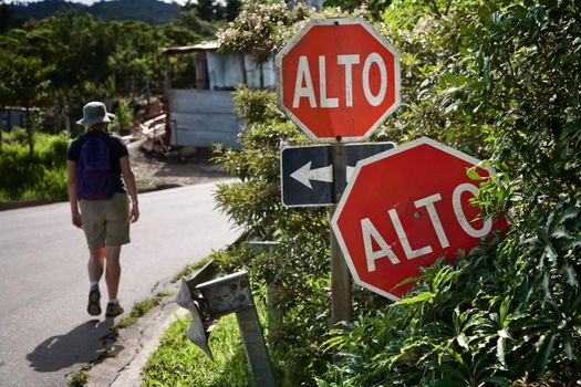 Hiker near alto signs at intersection in Santa Elena Costa Rica