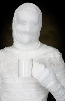 Man in bandage with mug on the black background