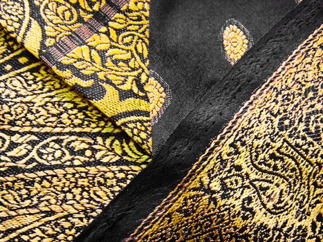 Closeup of a black and yellow saree with detailed floral designs