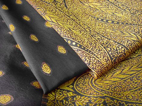 A folded black and yellow saree with floral designs
