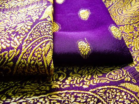 A folded purple saree with floral designs