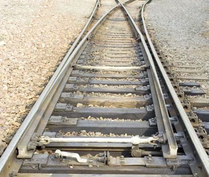 arrow crossing railway tracks receding into the distance