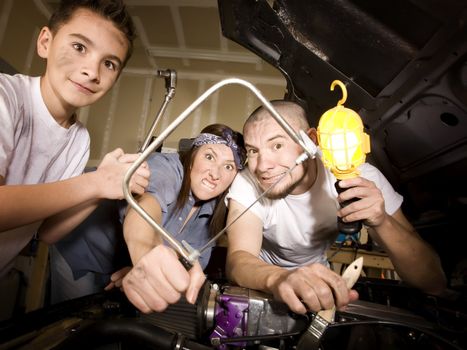 Hapless family of mechanics working on car with all the wrong tools