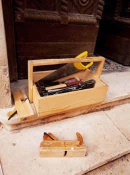 Old wood working tools on stone steps of a building