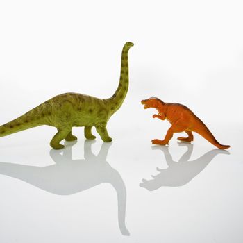 Plastic toy Tyrannosaurus and Apatosaurus dinosaurs.