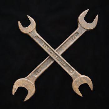 Two crossed crescent wrenches.