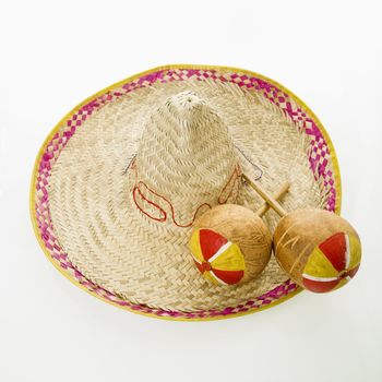 Pair of handmade Mexican maracas percussion musical instruments on sombrero straw hat.