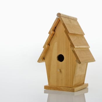 Wooden birdhouse against white background.