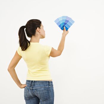 Woman trying to choose color for interior wall.