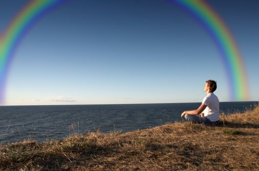 meditation at the seashore with big rainbow