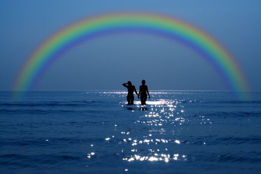 silhouette of two girls holding hands under rainbow