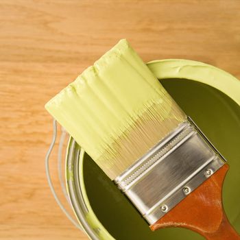 High angle view of paintbrush resting on paint can.