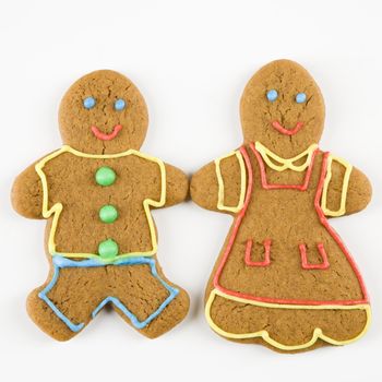 Male and female gingerbread cookies holding hands.
