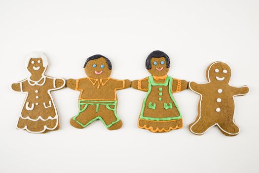 Four male and female gingerbread cookies holding hands