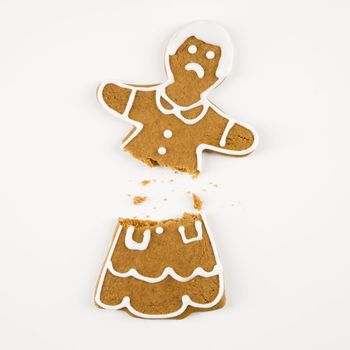 Frowning female gingerbread cookie broken in half.