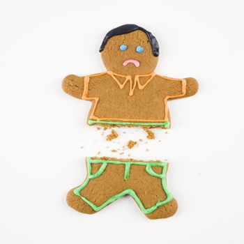 Frowning male gingerbread cookie broken in half.