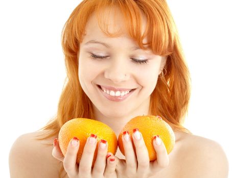 picture of cheerful redhead holding two oranges over white