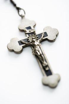 Christian rosary crucifix on white background.