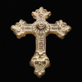 Ornamental religious cross against black background.