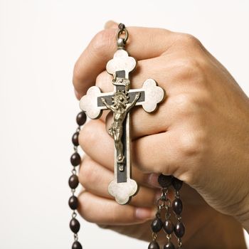 Woman's hands holding rosary with crucifix.