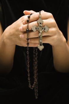 Woman holding rosary with crucifix.