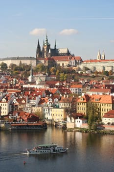 View of Prague with castle and tourboat on the river