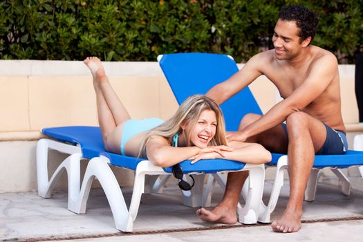 A happy couple relaxing beside a pool.