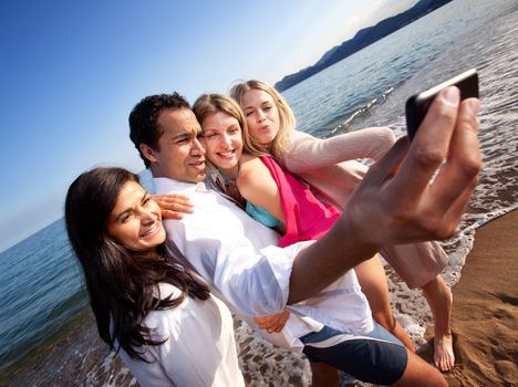 A group of young adults taking a self portrait with a cell phone
