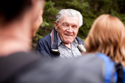 A grandfather talking a group of grandchildren