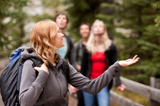 A woman hiker holding her hand out to feel rain