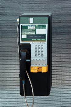 A modern payphone on a silver background