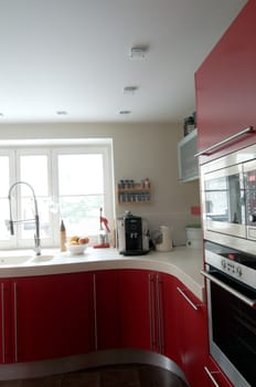 Red modern kitchen. Interiors. Cupboard. Table top.