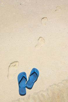 An image of blue thongs at the beach