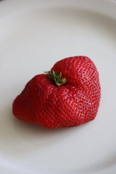 Close up of a strawberry on a plate.
