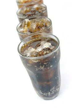 Glasses of cola isolated against a white background